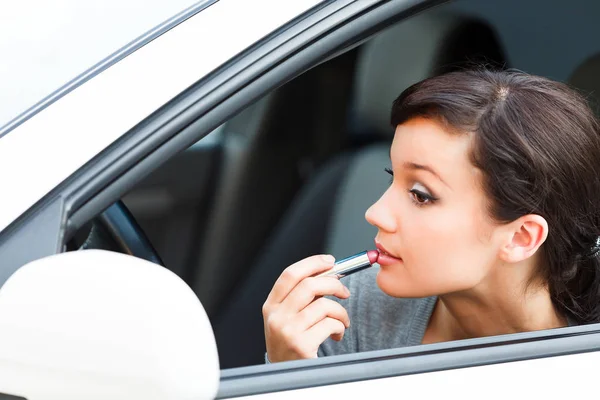 Guapa mujer conductor haciendo maquillaje — Foto de Stock