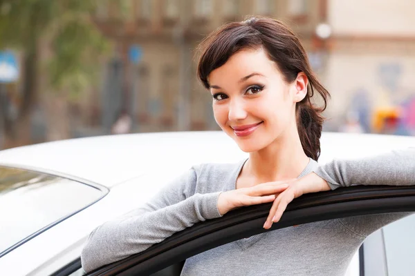 Feliz dueño de un coche nuevo. Joven mujer bonita conductor sonriendo a usted — Foto de Stock