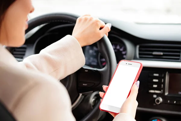 Primer plano del conductor femenino sosteniendo un smartphone o dispositivo de navegación —  Fotos de Stock