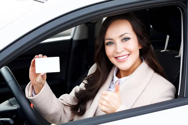 Motorista muito feminino mostrando cartão branco em branco e polegares para cima sinal de mão — Fotografia de Stock