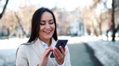 Onun smartphone açık havada kullanan güzel kadın
