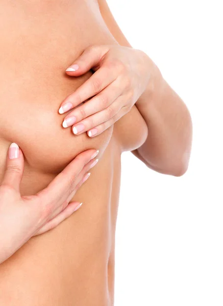 Donna nuda esaminando il seno, isolata su sfondo bianco — Foto Stock