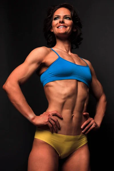 Fitness woman posing against a black background — Stock Photo, Image