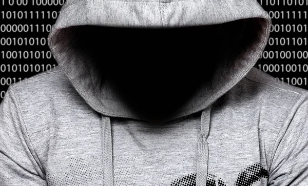 Hacker. Man in hood with face in a darkness with digital numbers behind