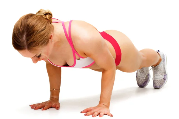 Jonge sport vrouw doen pushups geïsoleerd op witte achtergrond — Stockfoto