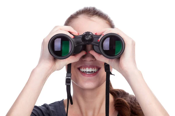Joven mujer sonriente mirando a través de prismáticos aislados en blanco — Foto de Stock