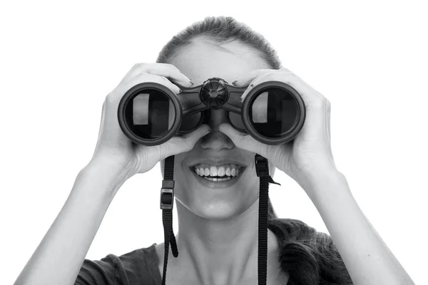 Young smiling woman looking through binoculars isolated on white — Stock Photo, Image