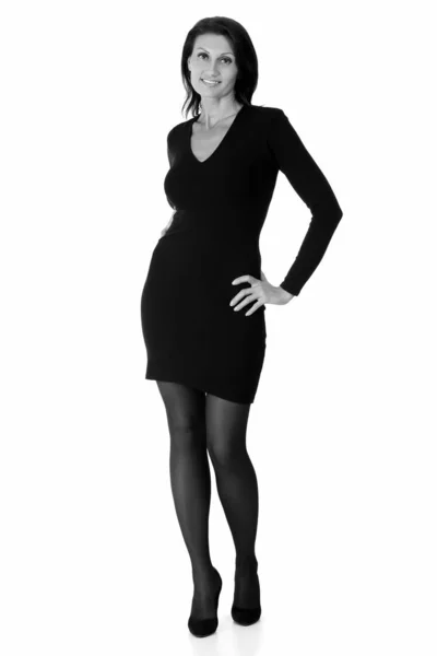 Slim donna indossa abito nero posa contro sfondo bianco — Foto Stock