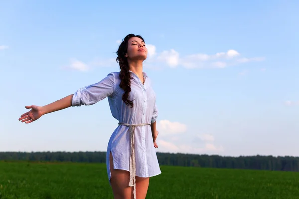 Mooie vrouw geniet van heldere lucht in de zomer veld — Stockfoto