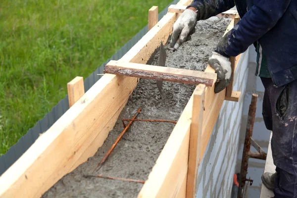 Arbetstagare nivåer betong i formsättning med hjälp av en murslev — Stockfoto