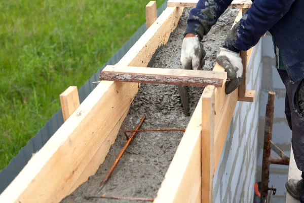 Arbetstagare nivåer betong i formsättning med hjälp av en murslev — Stockfoto