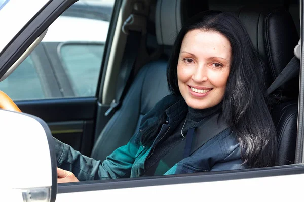 Mulher sênior feliz e sorridente em carro branco — Fotografia de Stock