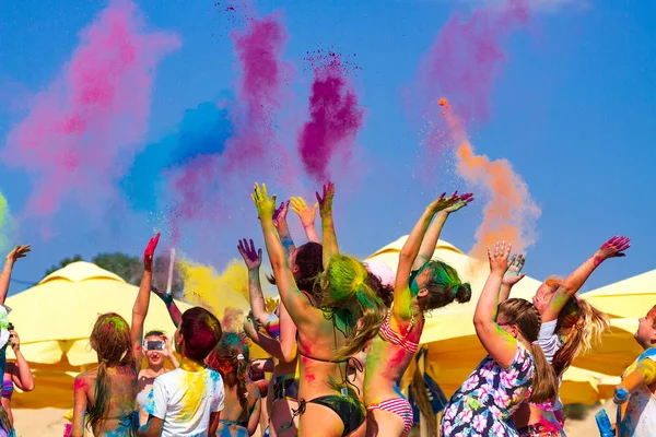 Mensen gooien kleurenpoeder tijdens het jaarlijkse evenement "Dag van de kleuren" — Stockfoto