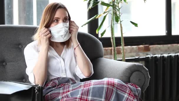 Kvinna Medicinsk Mask Håller Bok Medan Sitter Soffa Royaltyfri Stockvideo