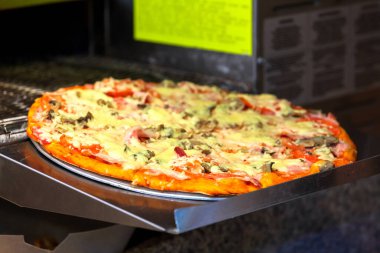 Kafe mutfağında modern bir pizza fırınında yemek pişirmek.