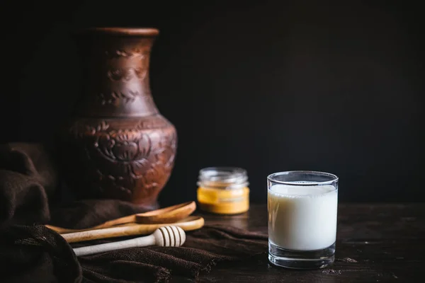 Glass jar with honey and milk — Stock Photo, Image
