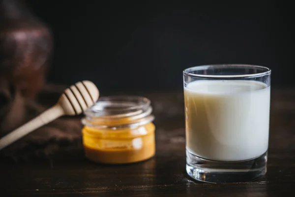 Стеклянная банка с медом и молоком — стоковое фото