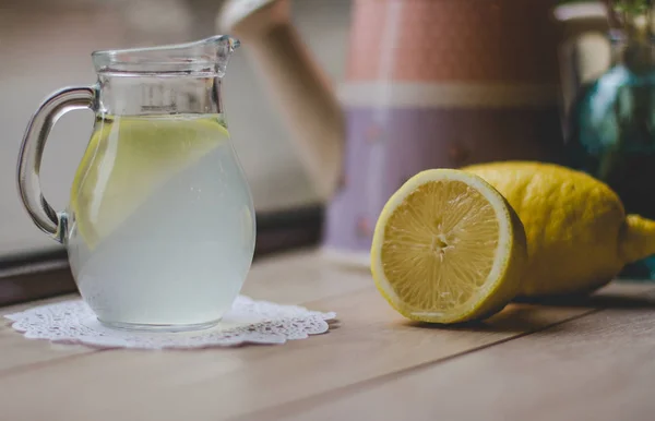 Water with lemon  in glass jug — Stock Photo, Image