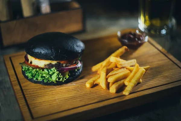 Hamburguesa negra con papas fritas —  Fotos de Stock