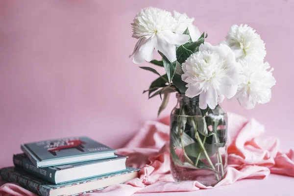 Beyaz peonies cam vazo ve kitaplar
