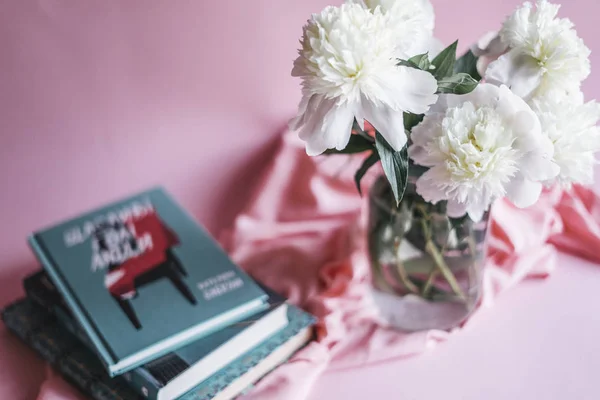 Beyaz peonies cam vazo ve kitaplar