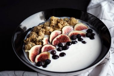 bowl with  fresh figs and berries on background, top view, healthy breakfast concept clipart
