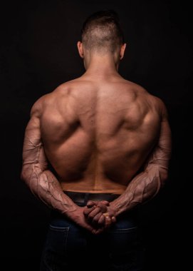 Kaslı erkek model kaslarını esnetiyor. 