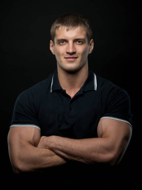 Spor tişörtsüz erkek model kaslarını esnetiyor.