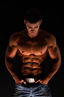 Spor tişörtsüz erkek model kaslarını esnetiyor.