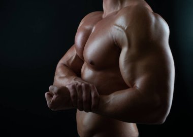 Spor tişörtsüz erkek model kaslarını esnetiyor.