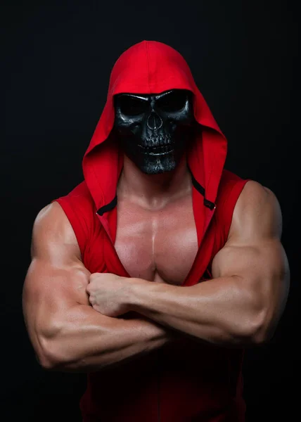 bodybuilder posing in a skull mask