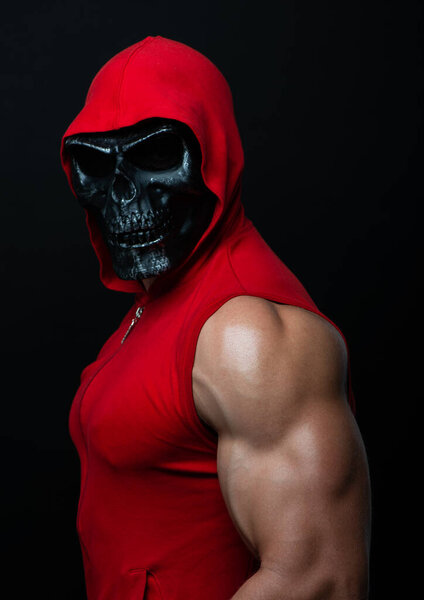 bodybuilder posing in a skull mask 