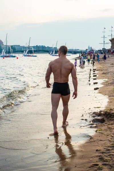 サンクトペテルブルクを望むビーチでの筋肉質の男性モデル — ストック写真