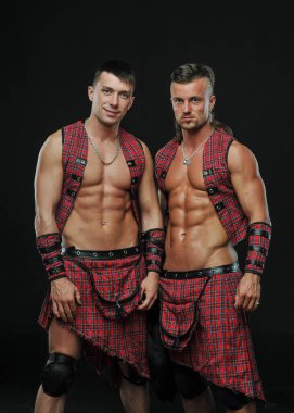 Muscled male models in kilt clipart