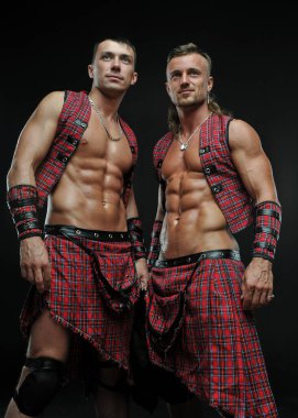 Muscled male models in kilt clipart