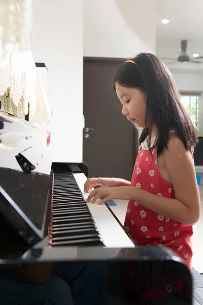 Маленькая азиатка за фортепиано — стоковое фото