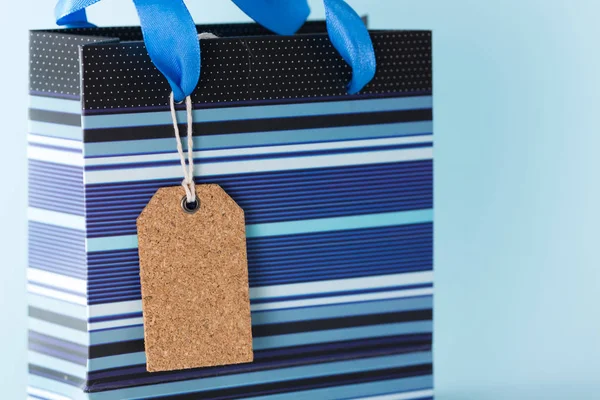 Blank tag on blue paper bag — Stock Photo, Image