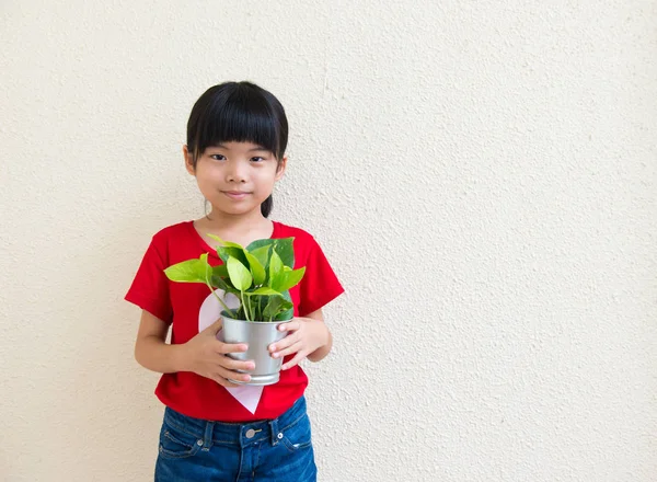 Petite fille tenant la plante en pot — Photo