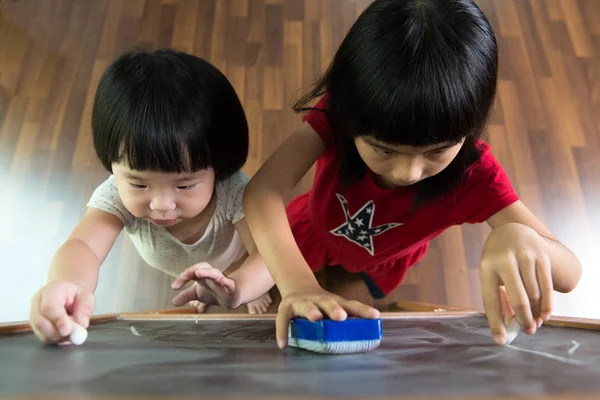 Two kids drawing on blackboard — Stock Photo, Image