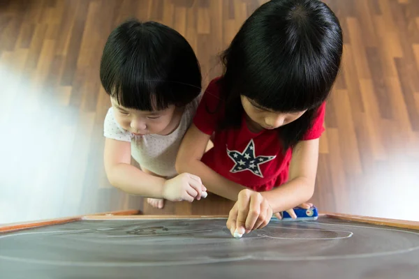 Two kids drawing on blackboard — Stock Photo, Image