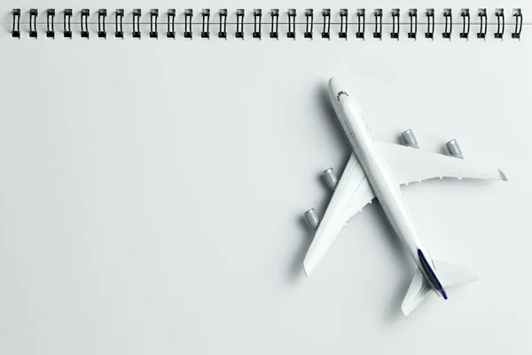 Модель самолета на спиральном блокноте — стоковое фото