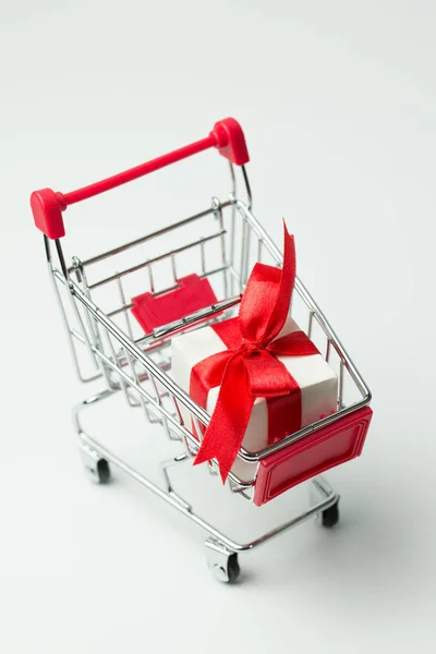 Weiße Geschenkschachtel mit rotem Band in einem Warenkorb gebunden — Stockfoto