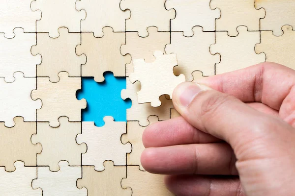 The last piece of a jigsaw wooden puzzle — Stock Photo, Image