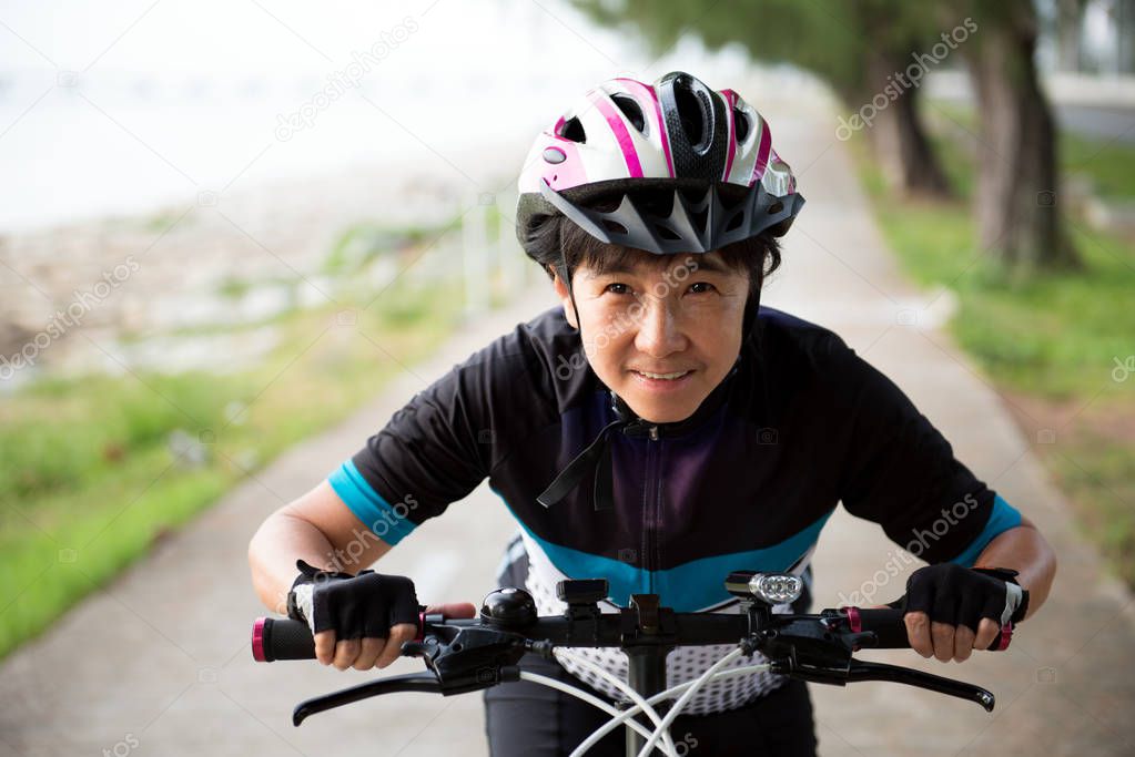 Joyful senior woman riding a bicycle
