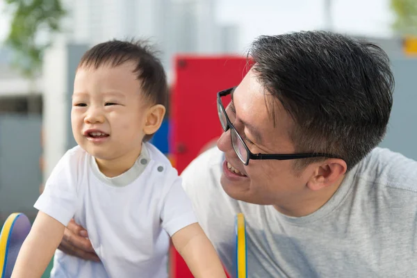 Azjatycka ojca z jego mały chłopiec o plac zabaw dla dzieci — Zdjęcie stockowe