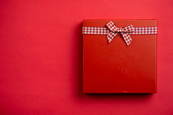 Επίπεδη θέσει ένα ενιαίο κόκκινο χριστουγεννιάτικο δώρο στο κόκκινο — Φωτογραφία Αρχείου