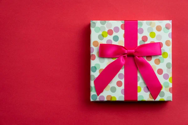 Vlak lag een enkel stipje kerstcadeau op rood — Stockfoto