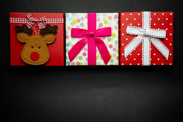 Flat lay three red Christmas gift on black — Stock Photo, Image