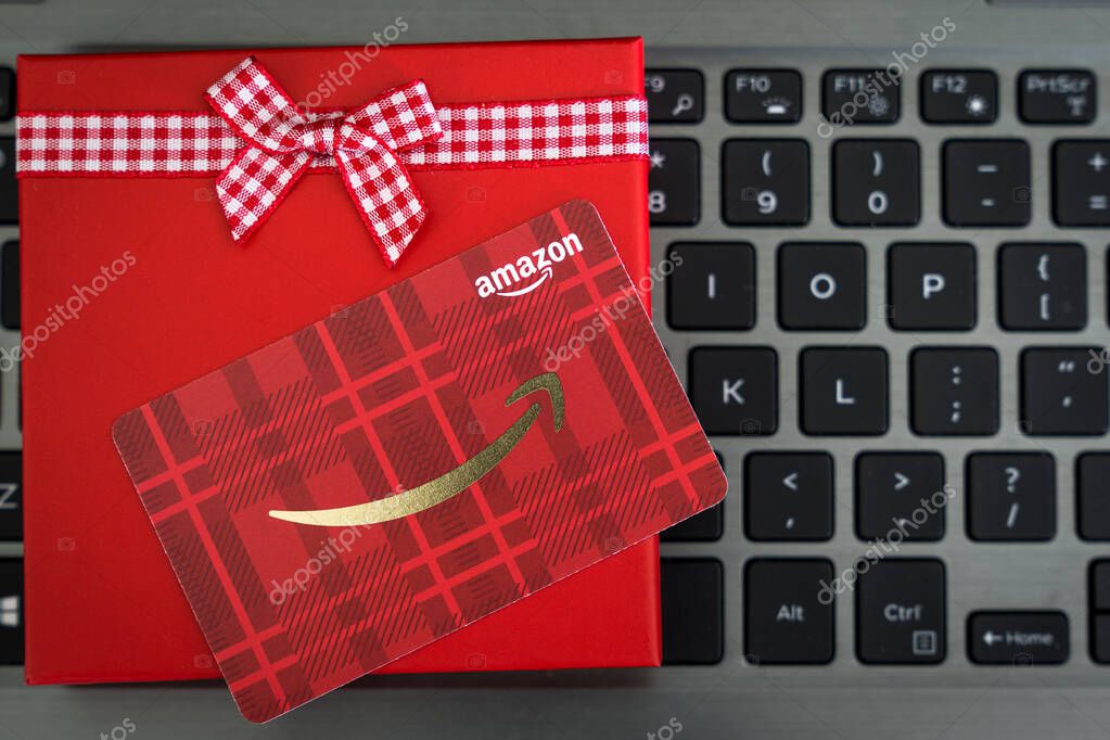 Detroit, USA - Nov 11, 2019 : Red color Amazon gift card in red box with reindeer ornament on laptop keyboard as a Christmas present