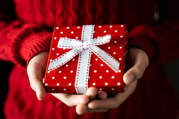 Young female hands holding gift box with ribbon — Stock Photo, Image